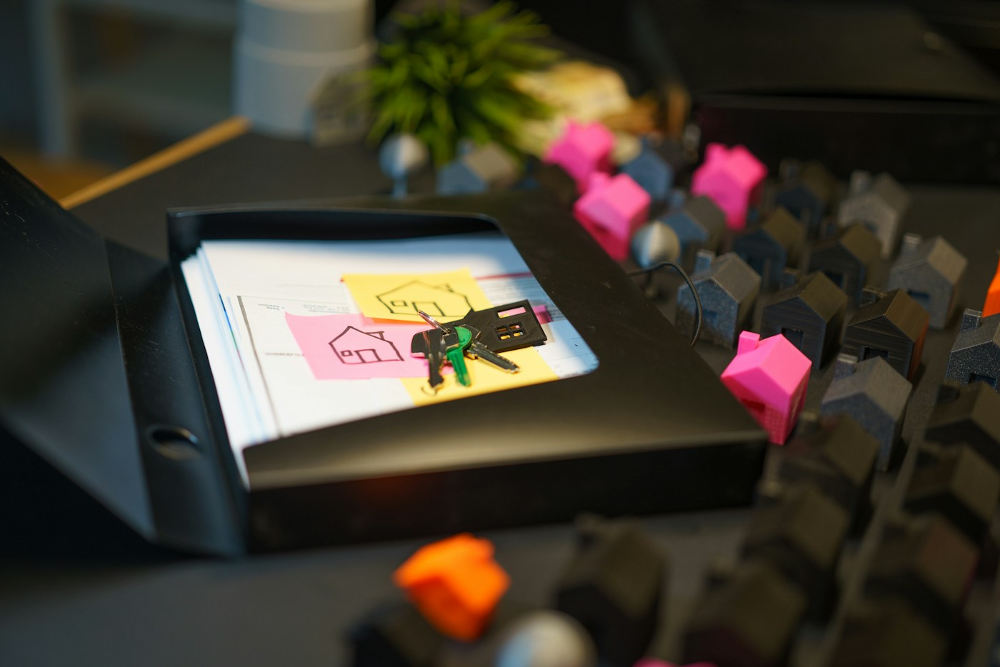 House keys and property paperwork beside a group of miniature houses