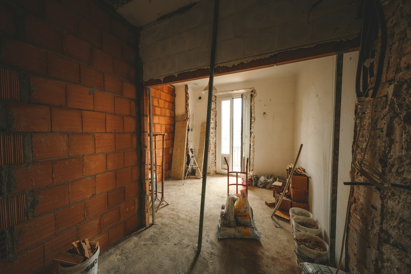 Unfinished interior with exposed brickwork and renovation materials